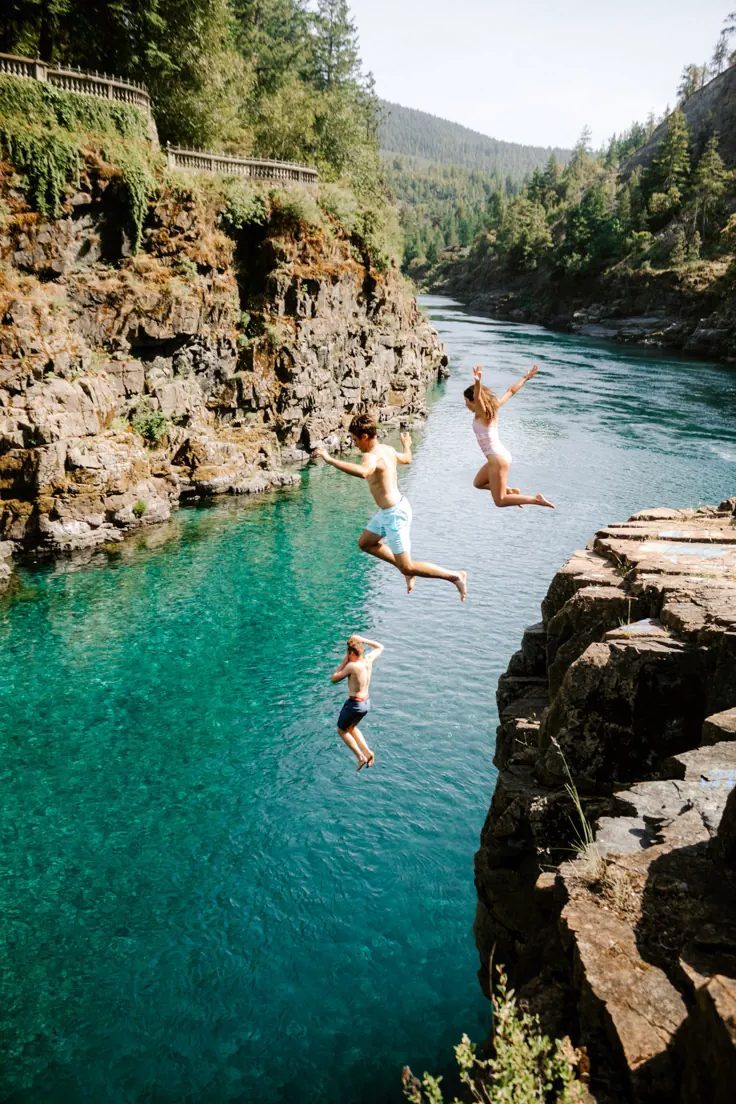 Swimmers leaping into clear turquoise water
